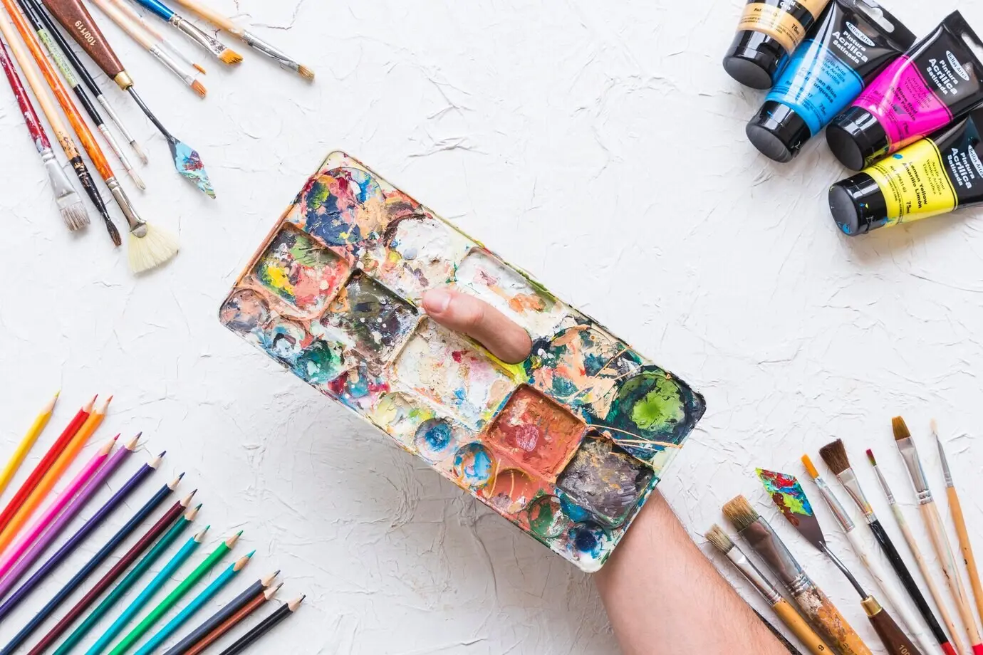 Malerpalette, umgeben von Malmaterial.